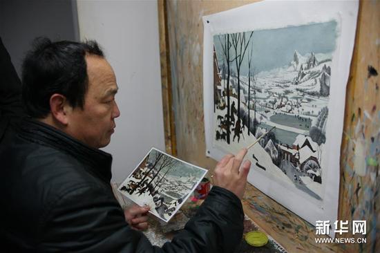 1月12日，一名画师在照着手中的图片作画。