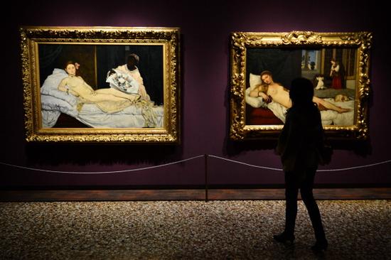 2013年“马奈回到威尼斯“展览中一位正在观看马奈《奥林匹亚》以及缇香的《乌尔比诺的维纳斯》的女性观众。 图片：Courtesy of GIUSEPPE CACACE/AFP/Getty Images。