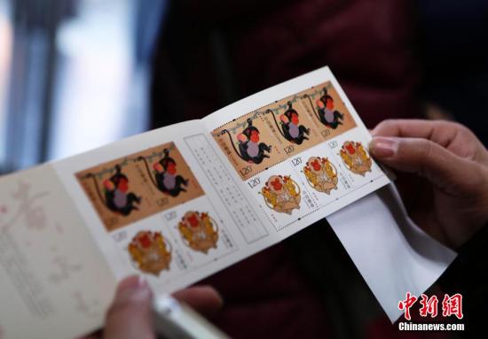 1月5日，北京市民展示刚刚购买的猴票。当日，中国第四轮猴年生肖邮票《丙申年》正式发售。该邮票1套2枚，面值为2.40元人民币。图案内容分别为：灵猴献瑞、福寿双至。 中新社记者 李慧思 摄
