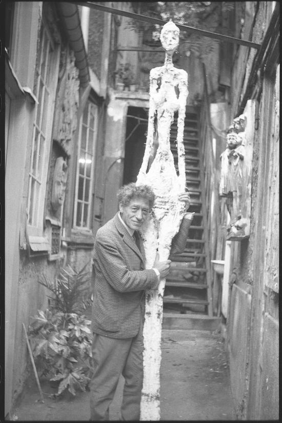 Alberto Giacometti with Tall Woman IV in the courtyard of his studio 阿尔贝托·贾科梅蒂与作品《高个女人（四）》在工作室庭院 1960 安妮特·贾科梅蒂拍摄