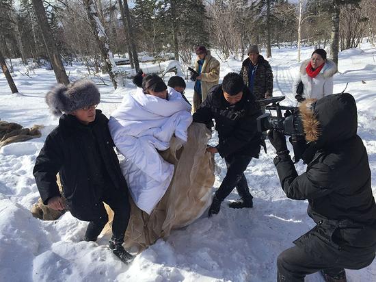 艺术家孔宁在工作人员的协助下准备在雪地里“洗澡”（图片：郭柏林） (2)