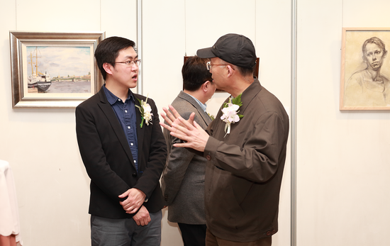 迟恒滨（左一）为嘉宾讲解作品创作过程