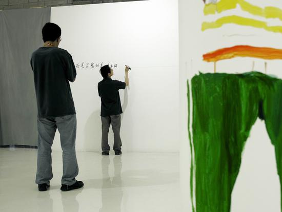 2006年9月为《多米诺》展览在墙上写前言，刘小东为尹吉男画速写。