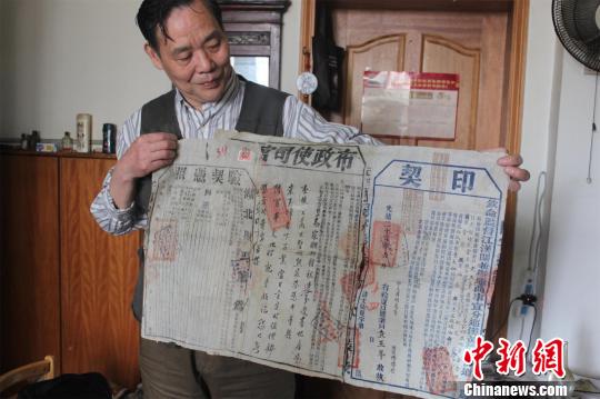 朱汉昌展示收藏的光绪26年契印，其上“江汉关”字样清晰可见 梁婷 摄