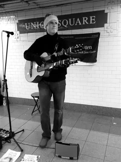 艺人斯科特在地铁中弹吉他。