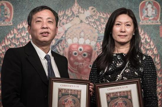 刘益谦、王薇夫妇从佳士得手中接受之前以创纪录价格拍下的西藏唐卡收藏证书。图片：Phillipe Lopez, courtesy AFP.