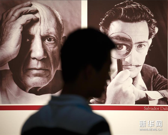 5月31日，利精观众从展览宣传海报前走过