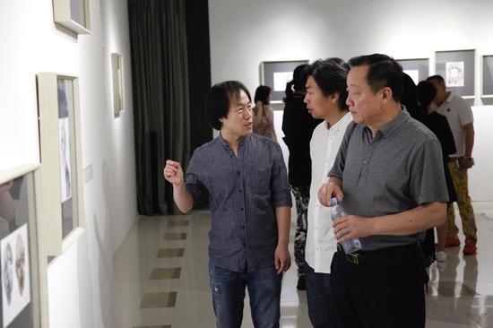 艺术家冯建宇（左）与鲁迅美术学院副院长李宝泉（右）、教务处处长胡秉文（中）在展览现场交流