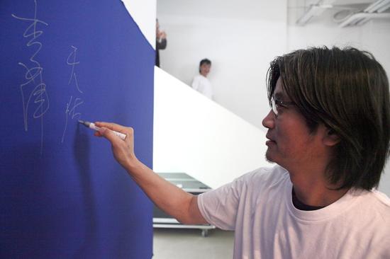 参展艺术家王天德在签到墙签名