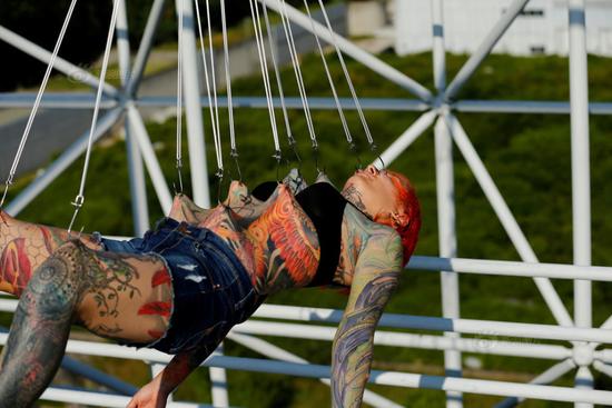 当地时间6月7日，克罗地亚萨格勒布，专业身体艺术家Dino Helvida和女朋友用10个钩子穿过28岁美国女子Kaitlin的皮肤，然后将她悬挂在空中。供图：视觉中国