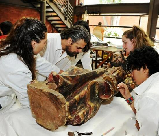 考古人员在对耶稣木雕进行研究