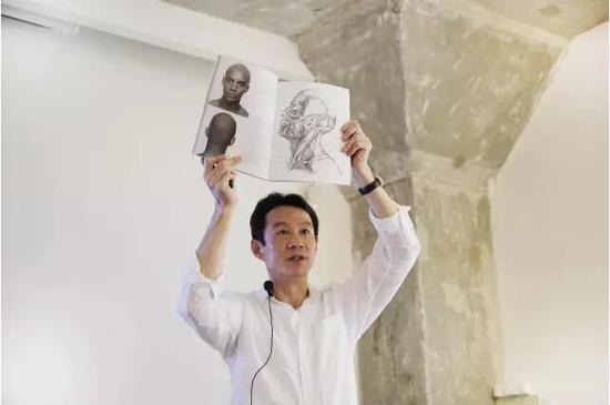 陈先生为观众展示人体骨骼和肌肉纤维的画册