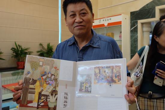 第一位购买者尚先生向记者展示《红楼品梦》大版册