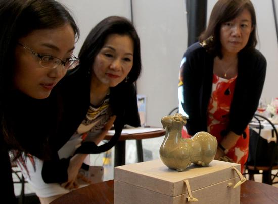 嘉宾欣赏古瓷藏品“三国两晋青瓷羊形烛台”