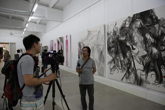 艺术家马岩在自己的作品《若有来生组画 断桥》前接受媒体采访