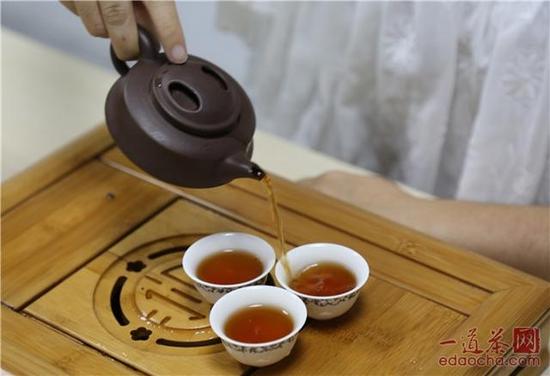 将茶汤注入茶杯之中