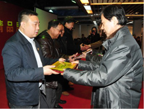 5中国工艺美术博览会上，杨晓枫给景泰蓝传人张同禄的儿子张旭授奖