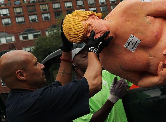 工人们在移除这座非法安装的共和党总统候选人唐纳德·特朗普的雕像，纽约工会广场公园，2016年8月18日。图片：Courtesy of Spencer Platt/Getty Images