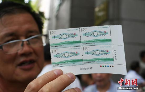 一位杭州市民展示出自己买到的“G20杭州峰会纪念邮票”。 中新社记者 王刚 摄