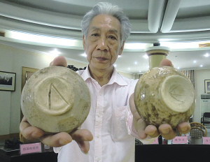 图为闻长庆展示刻有类希腊字母的古越青瓷器。(南华 摄)