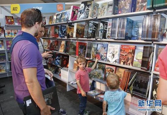 9月3日，在比利时布鲁塞尔，小朋友在漫画节上挑选漫画书。