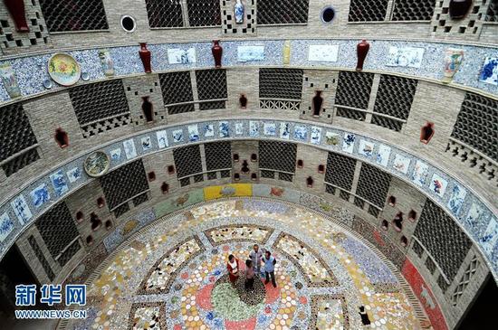 9月21日，余二妹（左二）向慕名而来的游客介绍“瓷宫”。新华社记者 万象 摄 图片来源：新华网