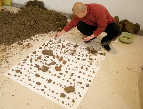 谭海山《1立方土和里面的628样物品》行为图片；2008