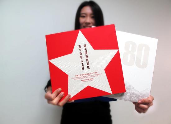 工作人員展示《雄關漫道真如鐵,而今邁步從頭越》郵冊