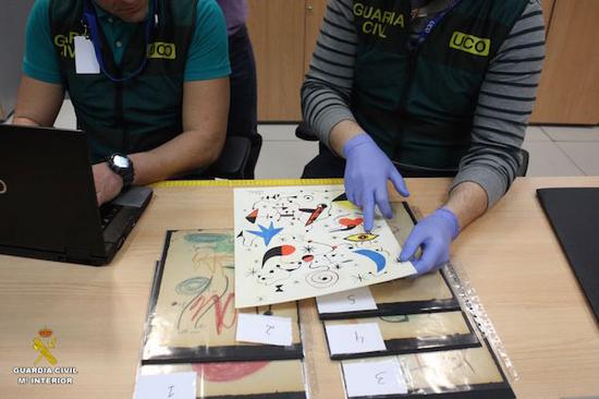 两位官员在审查胡安·米罗的伪作。图片：Courtesy of Guardia Civil