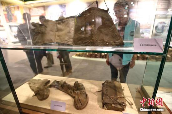 　　图为展出的侵华日军用防毒手套（上）、侵华日军用防化鞋（下左）、侵华日军九六式轻防毒面具（下右）。中新社记者 泱波 摄