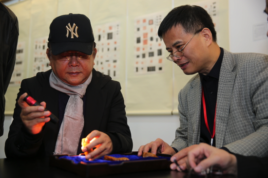 2016嘉德典亞古董藝術周落幕 吸引近萬觀眾看展(圖3) 藏家、演員王剛與藝友齋主人梁章凱先生仔細觀賞田黃作品