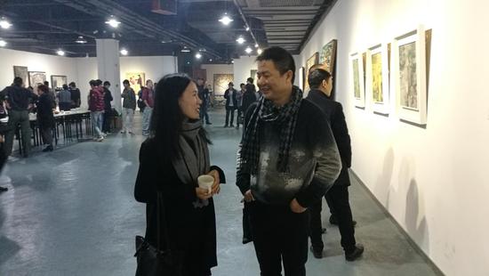 图14艾蕾尔博士与参展艺术家邓坤先生在1号展厅讨论作品