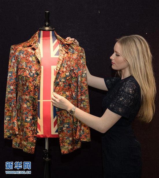 12月12日，在英国首都伦敦，一名邦瀚斯拍卖行的工作人员展示一件“滚石乐队”成员基思·理查兹穿过的演出服。 拍卖将于12月15日举行。新华社/欧新