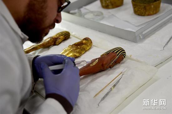 一名专家在大埃及博物馆木制品研究室内修复文物