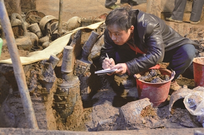 杨军在考古现场对出土编钟进行记录。
