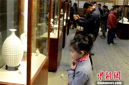 小观众正在欣赏陶瓷展览。中新社记者 刘可耕 摄