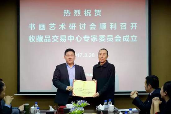 吉林省文化产权交易所副总裁贾永军（左）向专家王连敏教授（右）颁发聘书