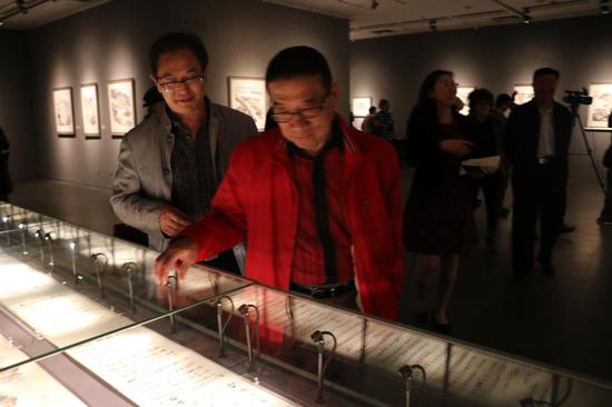 本次画展策展人王鸿儒先生（左一）和中国当代著名艺术市场评论家、美术评论家、鉴赏家齐建秋先生一起观看画展
