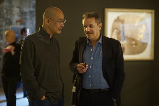 中国馆策展人邱志杰（左）在展览现场与朋友交谈（摄影：陈旖）