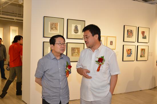 　中央美术学院人文学院院长尹吉男（左）与中央美术学院继续教育学院院长毕建勋（右）展览现场交流