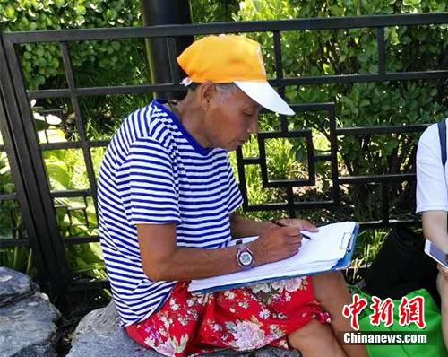自称“张老太”的画师在什刹海附近画肖像。中新网记者 宋宇晟 摄