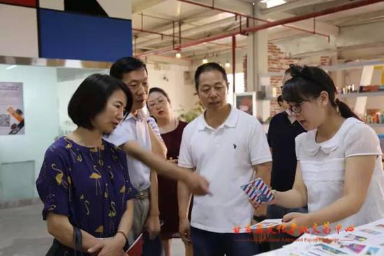 工作人员向调研组一行演示甘肃文交中心AR文创产品