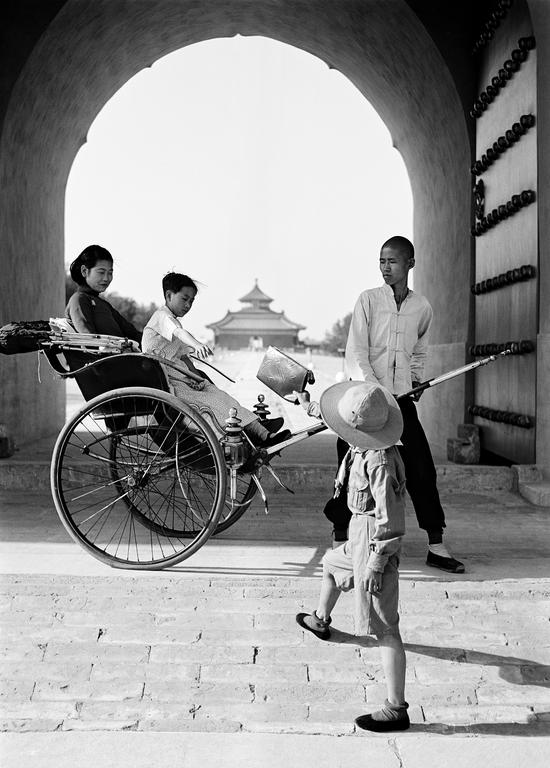 黄包车上的母子接过皮包。中国，1930年代