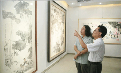 中宣部原秘书长官景辉、贾广健在展览现场交谈