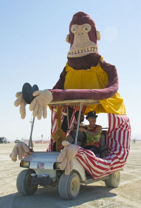 两位前来庆祝节日的人，他们将自己的高尔夫球车装扮成一个大型动物玩偶