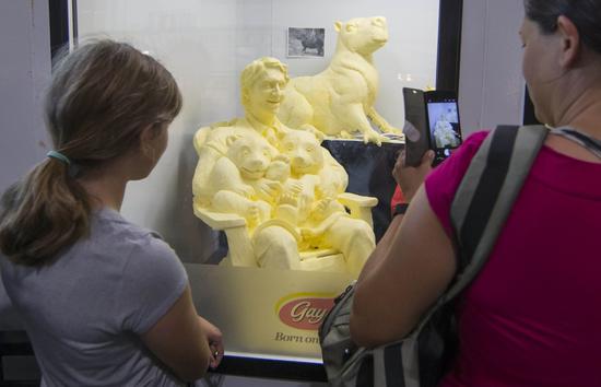 8月30日，在加拿大多伦多国家展览会上，人们参观加总理特鲁多怀抱两只大熊猫幼崽的黄油雕塑作品。邹峥/新华社