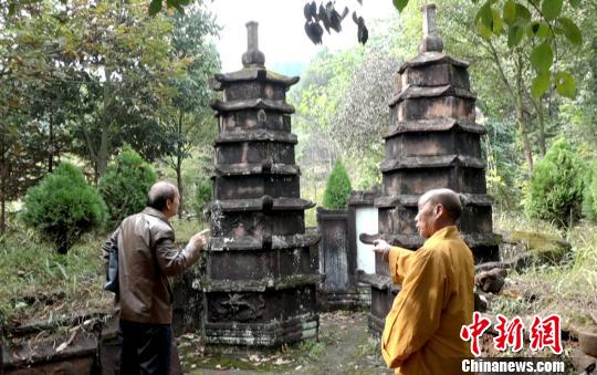 龙岩寺住持(右)向文史专家介绍双子墓塔。　徐志雄 摄