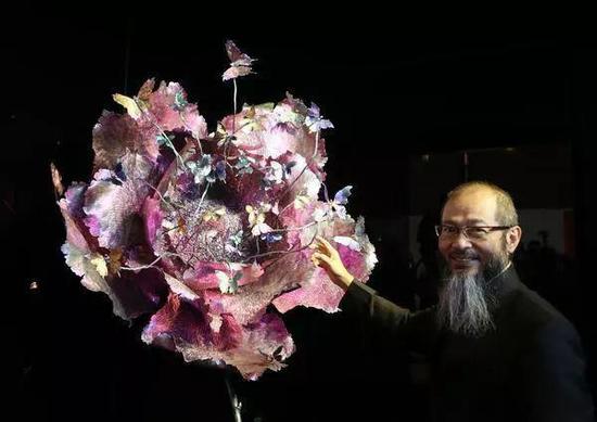 2015年11月28日陈世英在香港会展中心举行的其个人作品《梦光水》展览上，向嘉宾介绍他最新创作的大型珠宝艺术作品《心花振翅》