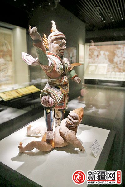 新疆博物馆里展出的彩绘天王踏鬼木俑（记者蒋晓摄）