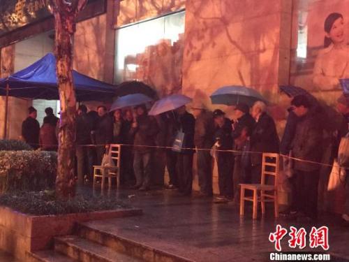 1月5日清晨5點半,在上海靜安郵政支局,市民冒著寒風與冷雨,撐傘排隊,搶購首發(fā)的戊戌狗年生肖郵票。 郭容 攝